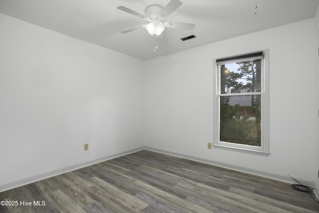 empty room with a ceiling fan, baseboards, visible vents, and wood finished floors