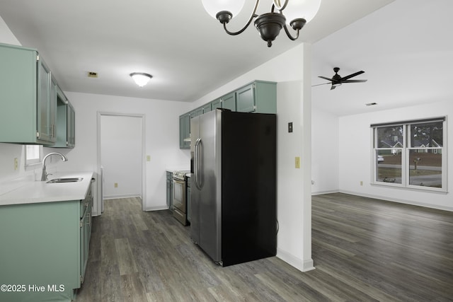 kitchen featuring a sink, stainless steel appliances, dark wood finished floors, green cabinets, and light countertops