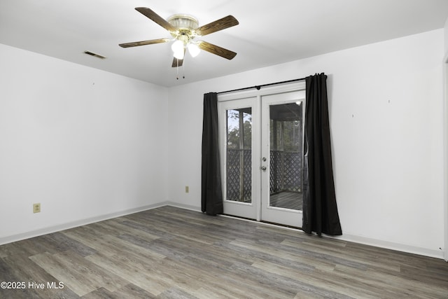 spare room featuring baseboards, french doors, a ceiling fan, and wood finished floors