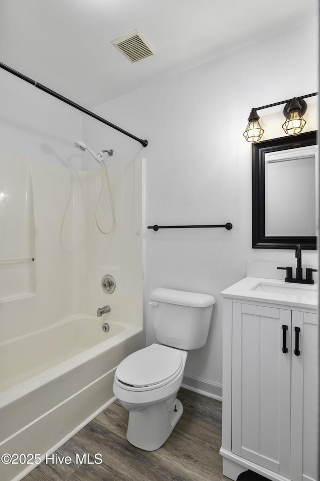 full bath with toilet, wood finished floors, vanity, visible vents, and  shower combination