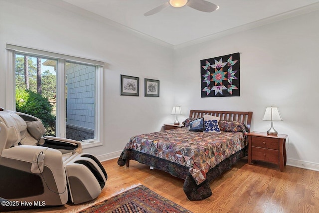 bedroom with baseboards, wood finished floors, crown molding, and ceiling fan