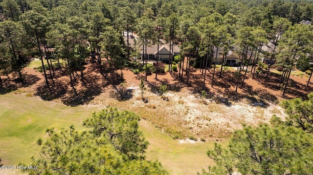 aerial view of property and surrounding area with a heavily wooded area