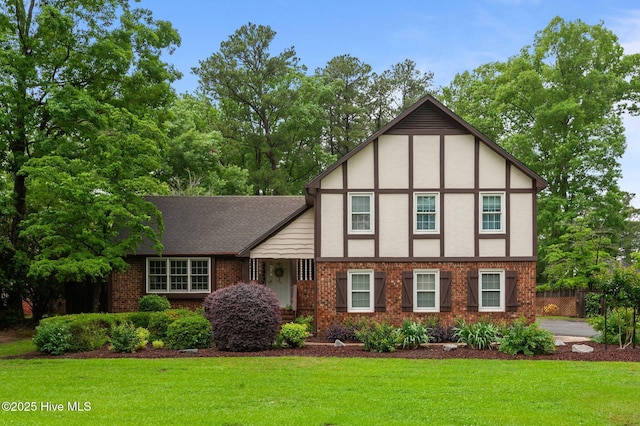 104 N Reed Dr, Washington, NC 27889 - tudor-style house featuring a front yard, brick siding, and stucco siding