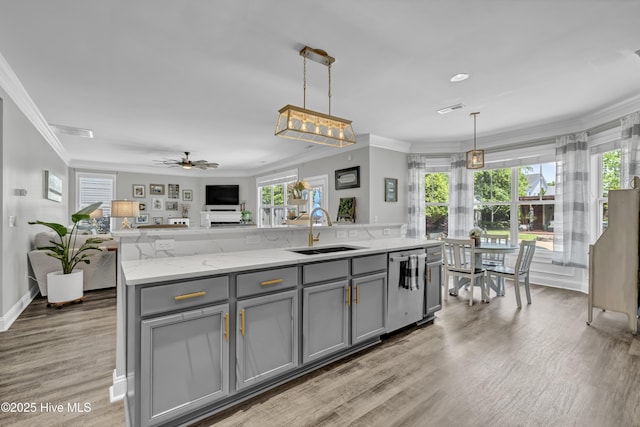 kitchen featuring stainless steel dishwasher, ornamental molding, gray cabinetry, and a sink