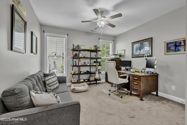 carpeted office space with baseboards and ceiling fan