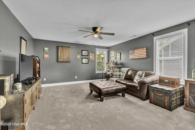 living room with carpet flooring, baseboards, and a ceiling fan