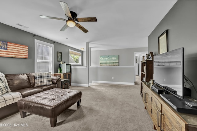 living area with baseboards, ceiling fan, visible vents, and light colored carpet