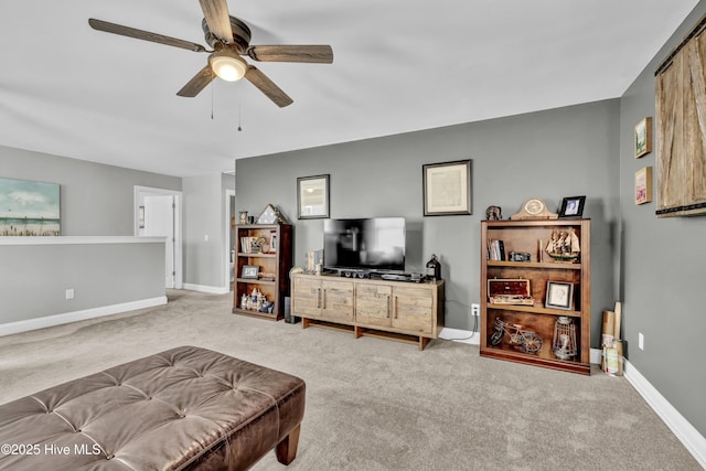 carpeted living area featuring a ceiling fan and baseboards