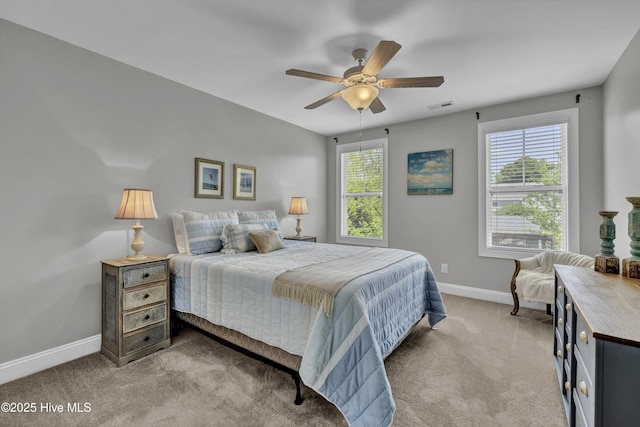 bedroom with visible vents, baseboards, ceiling fan, and light carpet