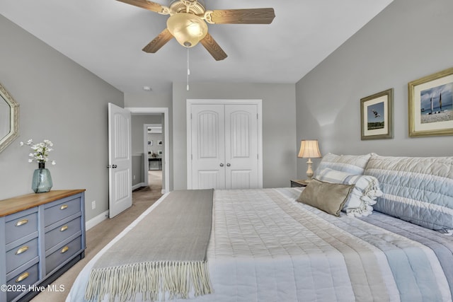 bedroom with baseboards, a closet, a ceiling fan, and light colored carpet