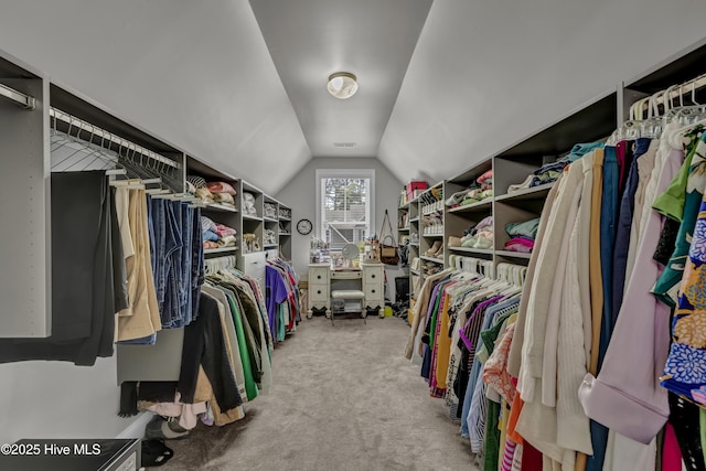 spacious closet featuring vaulted ceiling and carpet floors