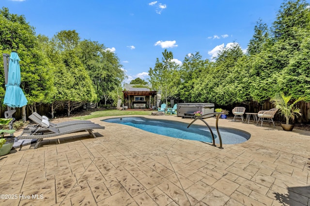 outdoor pool featuring a hot tub, fence, a gazebo, and a patio