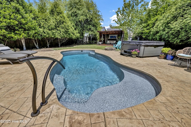 view of swimming pool featuring a hot tub, a fenced in pool, a patio area, and a fenced backyard