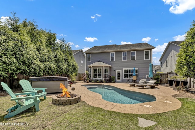 exterior space with an outdoor fire pit, a patio area, a hot tub, and a fenced backyard
