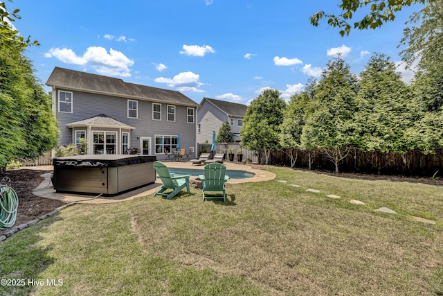 rear view of house with a lawn, a hot tub, a fenced in pool, and a fenced backyard