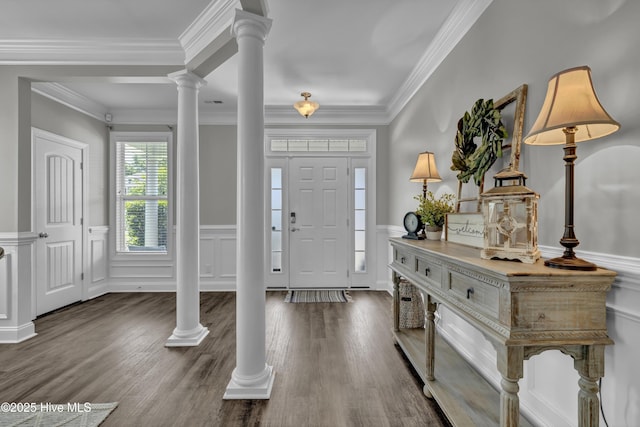 entrance foyer featuring a decorative wall, a wainscoted wall, wood finished floors, ornamental molding, and ornate columns