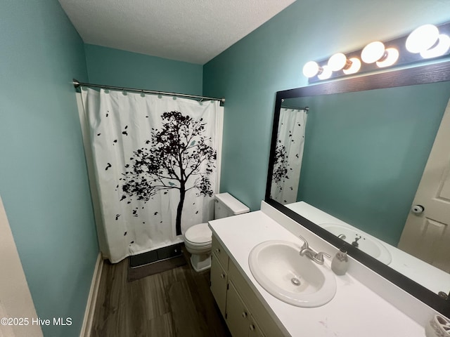 bathroom featuring wood finished floors, toilet, a textured ceiling, vanity, and a shower with curtain
