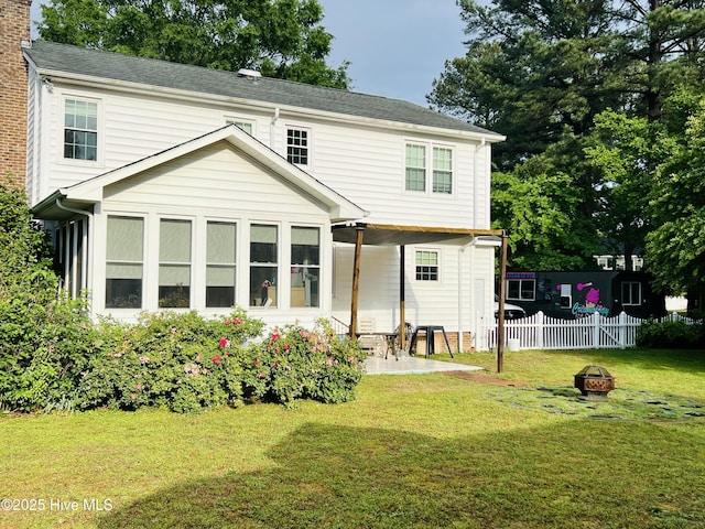 rear view of house with a fire pit and a patio