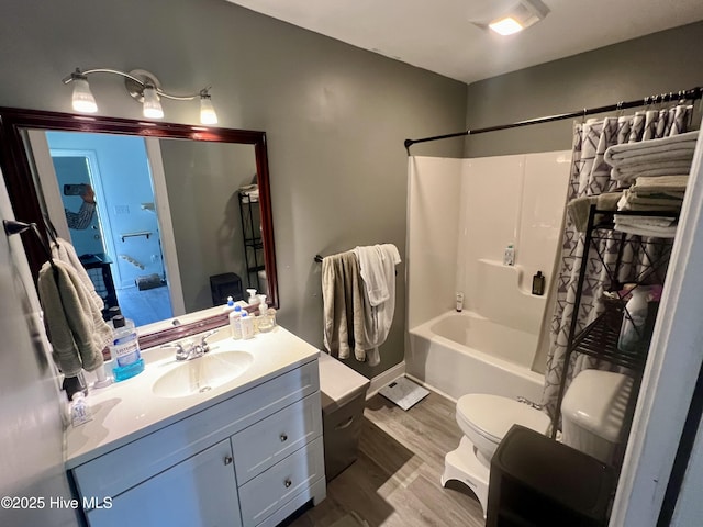 bathroom with toilet, wood finished floors, vanity, and shower / bath combo