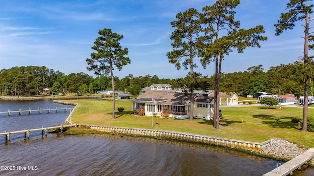 view of dock with a water view and a yard