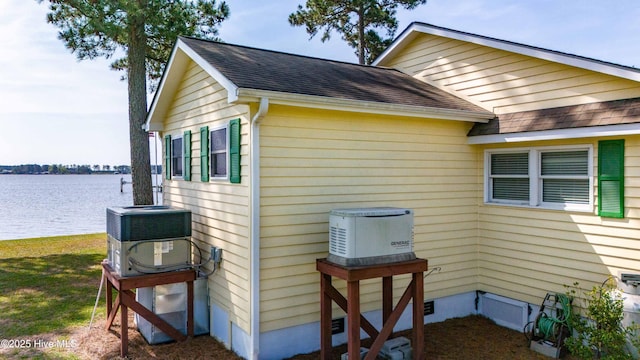 view of home's exterior featuring a water view, central AC unit, and roof with shingles