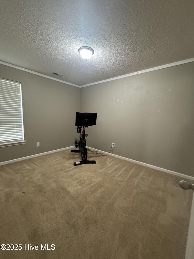 exercise room with carpet, a textured ceiling, baseboards, visible vents, and crown molding
