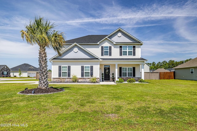 traditional home with fence, stone siding, and a front yard