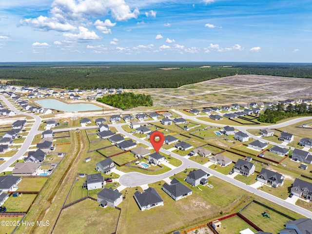 drone / aerial view with a water view, a residential view, and a view of trees