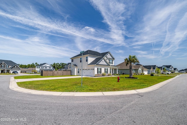 view of front facade featuring fence, an attached garage, a residential view, concrete driveway, and a front yard