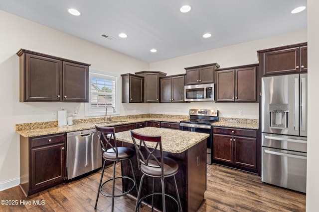 kitchen with visible vents, a sink, dark brown cabinetry, dark wood-type flooring, and appliances with stainless steel finishes