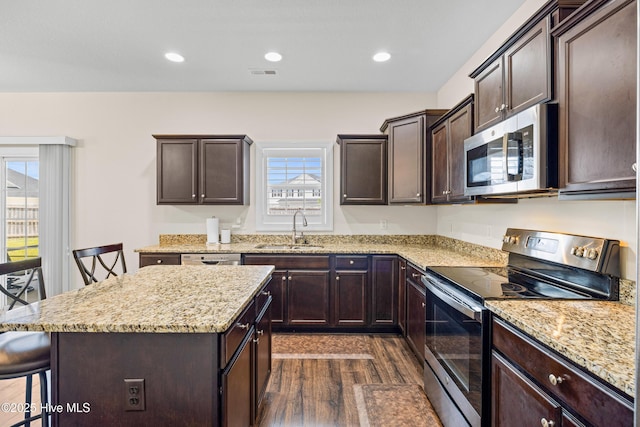 kitchen featuring a sink, visible vents, dark wood-style flooring, dark brown cabinetry, and appliances with stainless steel finishes
