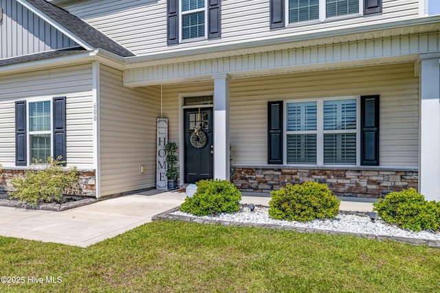 property entrance with stone siding, board and batten siding, covered porch, and roof with shingles