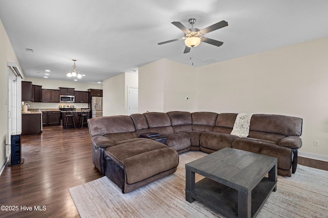 living room with recessed lighting, baseboards, dark wood finished floors, visible vents, and ceiling fan with notable chandelier