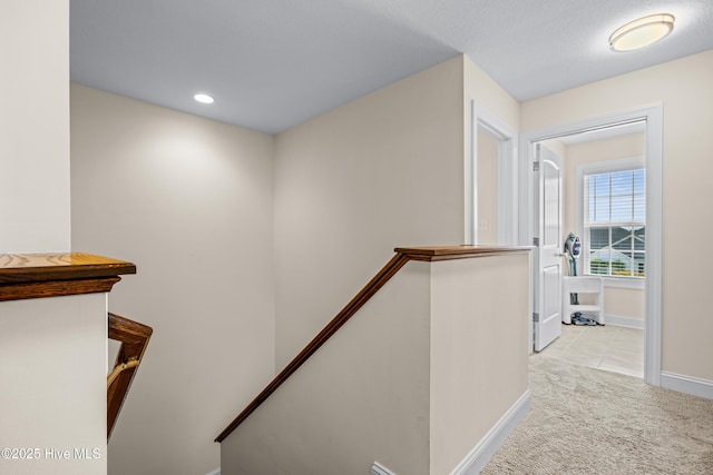 hallway featuring baseboards, carpet flooring, an upstairs landing, and recessed lighting