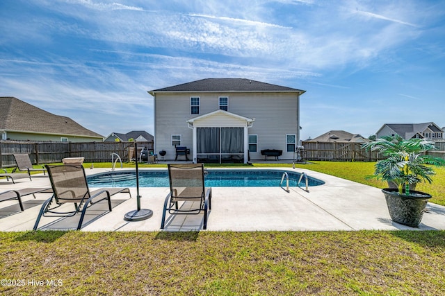 view of swimming pool with a yard, a patio, a fenced backyard, a fenced in pool, and a sunroom