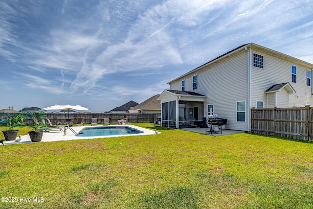 view of swimming pool featuring a yard, a fenced in pool, a patio, a sunroom, and a fenced backyard