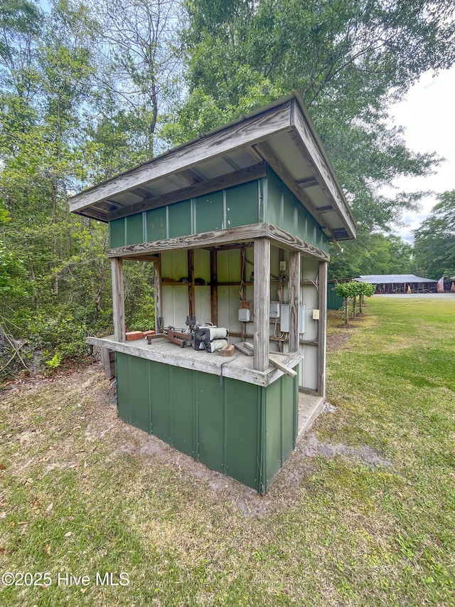 rear view of house featuring a lawn and an outbuilding