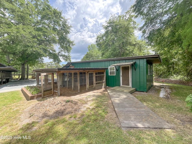 view of front of house featuring board and batten siding and an outbuilding