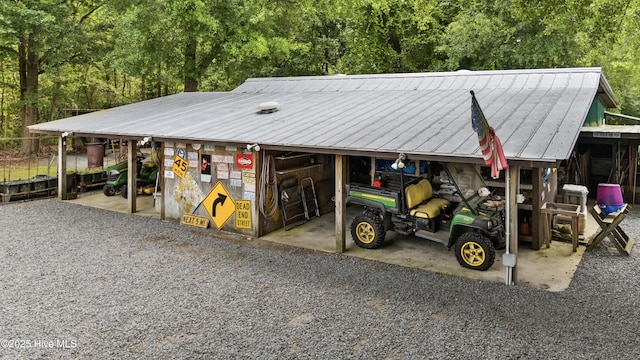 garage with a carport and a view of trees
