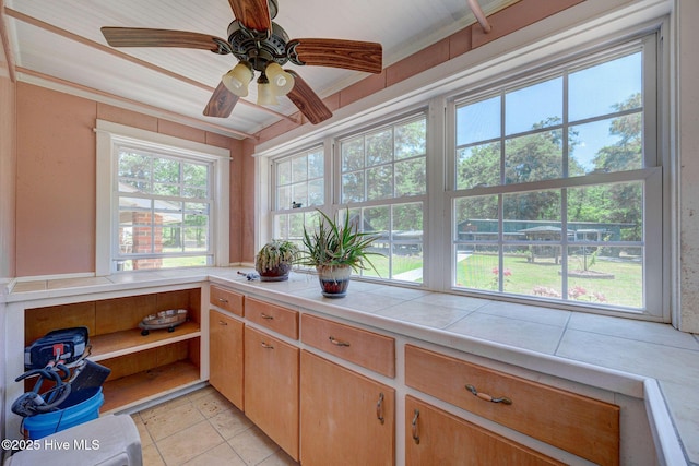 kitchen featuring tile countertops, ornamental molding, light tile patterned floors, ceiling fan, and open shelves