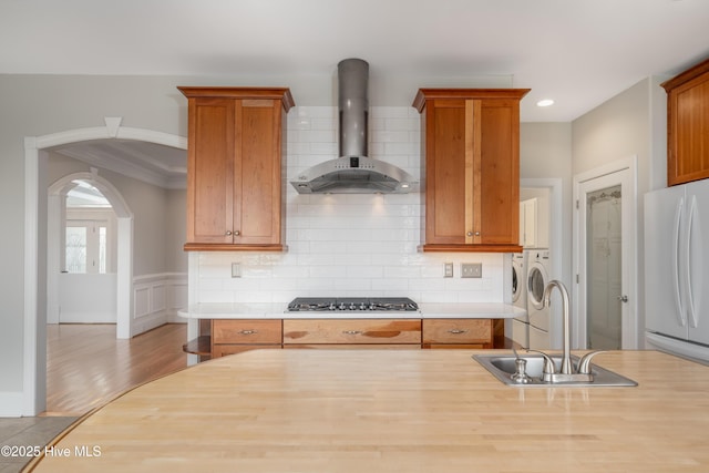 1835 Middle Sound Loop Rd, Wilmington, NC 28411 - kitchen with independent washer and dryer, wall chimney exhaust hood, freestanding refrigerator, a sink, and light countertops