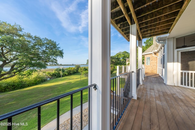 deck featuring a water view and a lawn