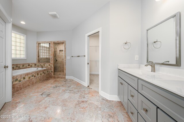 1835 Middle Sound Loop Rd, Wilmington, NC 28411 - bathroom featuring a stall shower, double vanity, a garden tub, a walk in closet, and baseboards