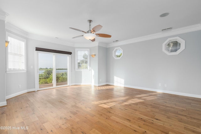 spare room with ceiling fan, light wood-type flooring, ornamental molding, and baseboards