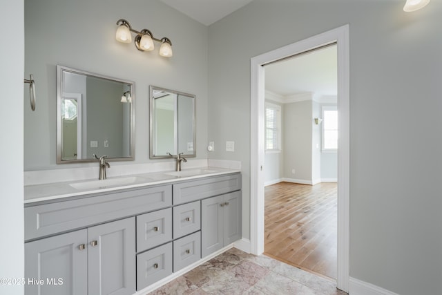 full bath with crown molding, baseboards, and double vanity