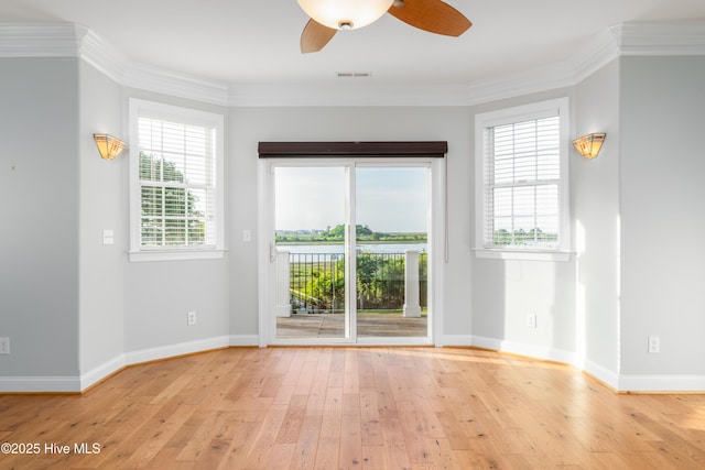 empty room with a ceiling fan, light wood-style floors, baseboards, and crown molding