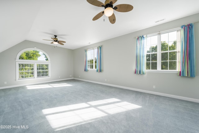 carpeted empty room with a ceiling fan, baseboards, and lofted ceiling