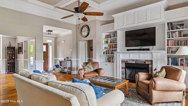 216 National Dr, Pinehurst, NC 28374 - living room featuring crown molding, a fireplace, ceiling fan, wood finished floors, and built in shelves