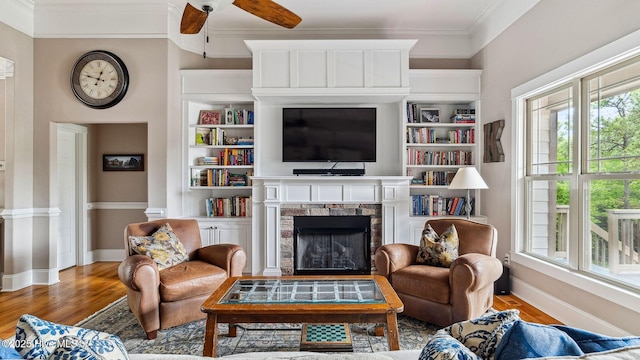 216 National Dr, Pinehurst, NC 28374 - living area with ornamental molding, baseboards, wood finished floors, a ceiling fan, and a fireplace