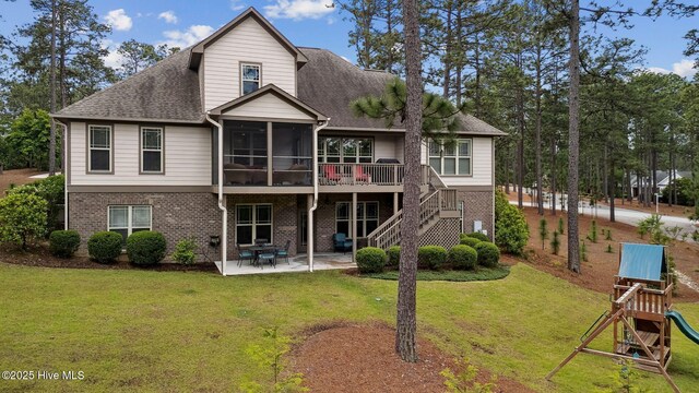 216 National Dr, Pinehurst, NC 28374 - rear view of property with a sunroom, a patio area, brick siding, and a lawn